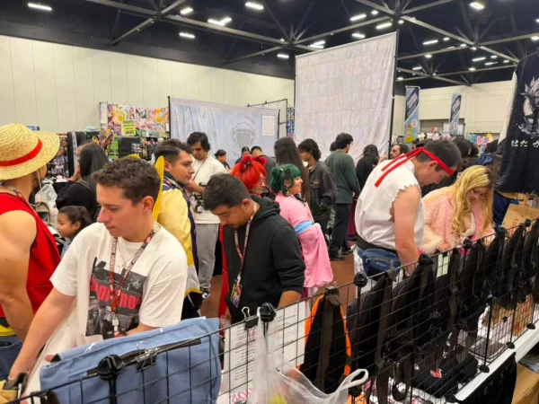 Visitors browsing anime merchandise at the Komikku Villa convention booth