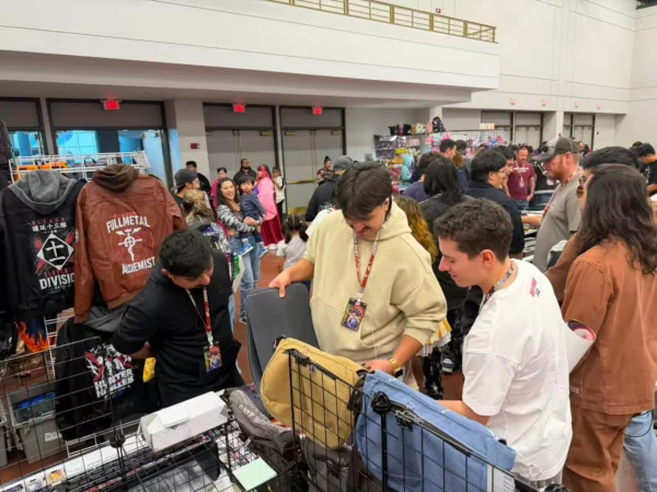 Visitors browsing anime merchandise at the Komikku Villa convention booth